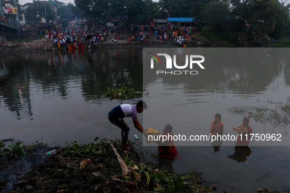 Devotees offer prayers to the sun god at a riverside 70 kilometers outside of Kolkata, India, on November 7, 2024, during the Chhath Puja fe...