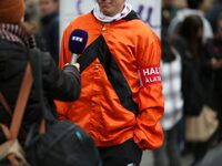 A protester wearing orange jockeys' silks and an armband reading ''Stop the tax'' speaks with the press as he participates in a demonstratio...