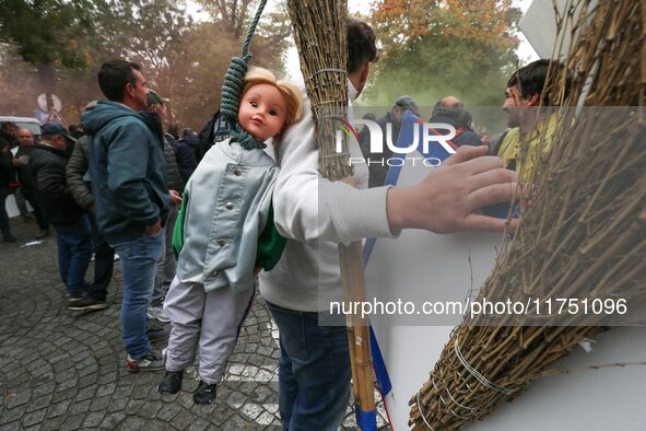 A protester carries a doll wearing a jockey jacket and hanging from a rope as he takes part in a demonstration organized by horse racing ass...