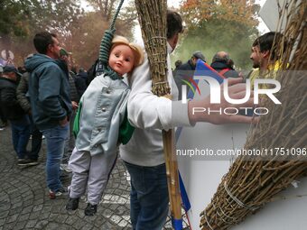 A protester carries a doll wearing a jockey jacket and hanging from a rope as he takes part in a demonstration organized by horse racing ass...