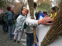 A protester carries a doll wearing a jockey jacket and hanging from a rope as he takes part in a demonstration organized by horse racing ass...