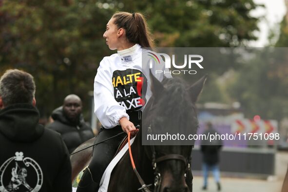 A jockey with her horse, wearing white jockey silks reading ''Stop the tax,'' takes part in a demonstration organized by horse racing associ...