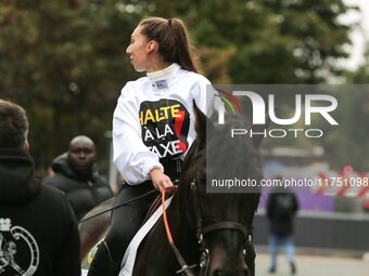 A jockey with her horse, wearing white jockey silks reading ''Stop the tax,'' takes part in a demonstration organized by horse racing associ...