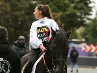 A jockey with her horse, wearing white jockey silks reading ''Stop the tax,'' takes part in a demonstration organized by horse racing associ...