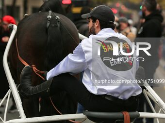 A jockey with her horse, wearing white jockey silks reading ''Keep jobs,'' takes part in a demonstration organized by horse racing associati...