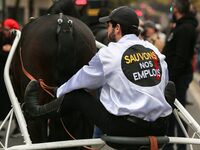 A jockey with her horse, wearing white jockey silks reading ''Keep jobs,'' takes part in a demonstration organized by horse racing associati...