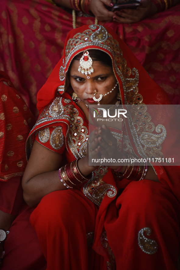 A Hindu woman devotee takes a rest after performing rituals in the river Ganga during the Hindu festival Chhath in Kolkata, India, on Novemb...