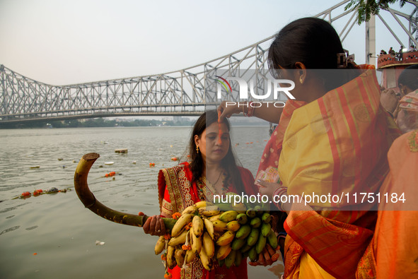 Hindu women devotees perform rituals in the river Ganga in front of the iconic Howrah Bridge during the Hindu festival Chhath in Kolkata, In...