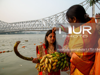 Hindu women devotees perform rituals in the river Ganga in front of the iconic Howrah Bridge during the Hindu festival Chhath in Kolkata, In...