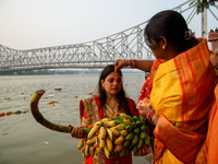 Hindu women devotees perform rituals in the river Ganga in front of the iconic Howrah Bridge during the Hindu festival Chhath in Kolkata, In...