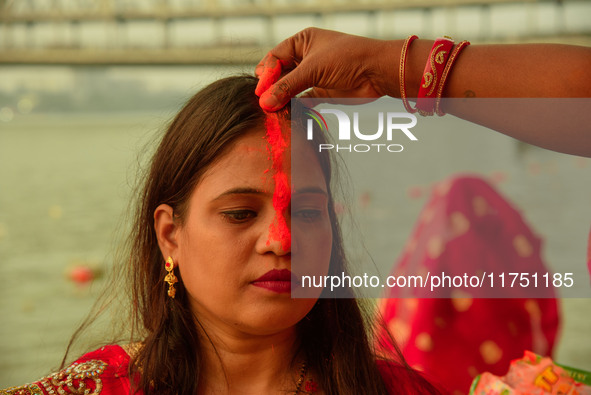 Hindu women devotees perform rituals in the river Ganga in front of the iconic Howrah Bridge during the Hindu festival Chhath in Kolkata, In...