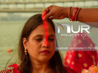 Hindu women devotees perform rituals in the river Ganga in front of the iconic Howrah Bridge during the Hindu festival Chhath in Kolkata, In...