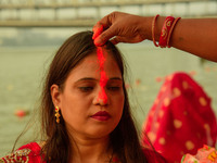 Hindu women devotees perform rituals in the river Ganga in front of the iconic Howrah Bridge during the Hindu festival Chhath in Kolkata, In...