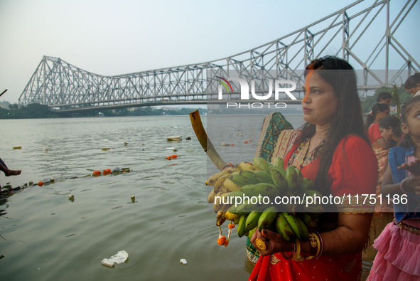 Hindu women devotees perform rituals in a water body of the river Ganga in front of the iconic Howrah Bridge during the Hindu festival Chhat...