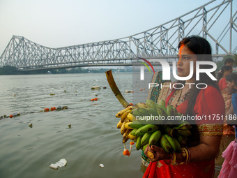 Hindu women devotees perform rituals in a water body of the river Ganga in front of the iconic Howrah Bridge during the Hindu festival Chhat...