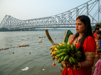 Hindu women devotees perform rituals in a water body of the river Ganga in front of the iconic Howrah Bridge during the Hindu festival Chhat...