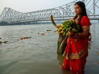 Hindu women devotees perform rituals in a water body of the river Ganga in front of the iconic Howrah Bridge during the Hindu festival Chhat...