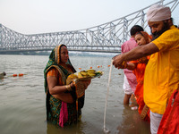 Hindu women devotees perform rituals in the river Ganga in front of the iconic Howrah Bridge during the Hindu festival Chhath in Kolkata, In...