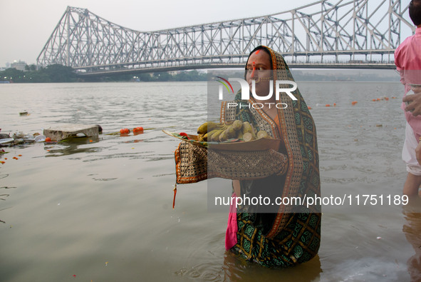 Hindu women devotees perform rituals in a water body of the river Ganga in front of the iconic Howrah Bridge during the Hindu festival Chhat...