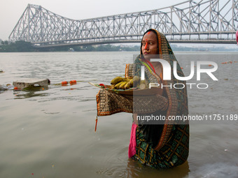 Hindu women devotees perform rituals in a water body of the river Ganga in front of the iconic Howrah Bridge during the Hindu festival Chhat...