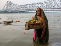 Hindu women devotees perform rituals in a water body of the river Ganga in front of the iconic Howrah Bridge during the Hindu festival Chhat...