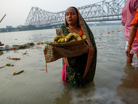 Hindu women devotees perform rituals in a water body of the river Ganga in front of the iconic Howrah Bridge during the Hindu festival Chhat...