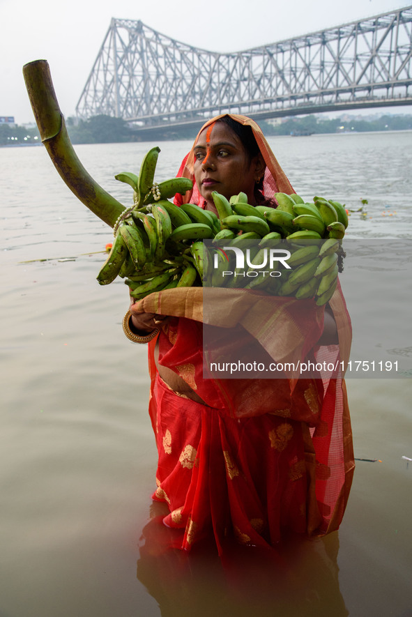 Hindu women devotees perform rituals in a water body of the river Ganga in front of the iconic Howrah Bridge during the Hindu festival Chhat...