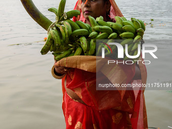 Hindu women devotees perform rituals in a water body of the river Ganga in front of the iconic Howrah Bridge during the Hindu festival Chhat...