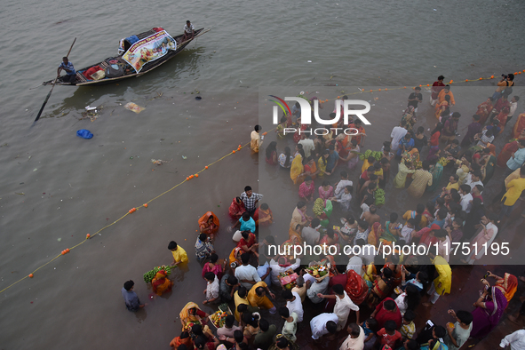 Hindu women devotees perform rituals in the river Ganga in front of the iconic Howrah Bridge during the Hindu festival Chhath in Kolkata, In...