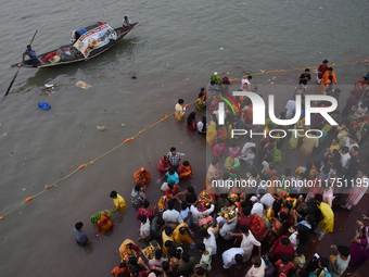 Hindu women devotees perform rituals in the river Ganga in front of the iconic Howrah Bridge during the Hindu festival Chhath in Kolkata, In...