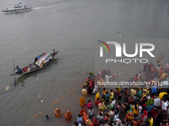 Hindu women devotees perform rituals in the river Ganga in front of the iconic Howrah Bridge during the Hindu festival Chhath in Kolkata, In...