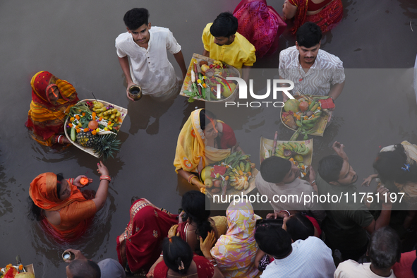 Hindu women devotees perform rituals in the river Ganga in front of the iconic Howrah Bridge during the Hindu festival Chhath in Kolkata, In...