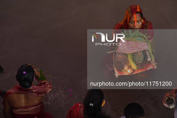 Hindu women devotees perform rituals in the river Ganga in front of the iconic Howrah Bridge during the Hindu festival Chhath in Kolkata, In...