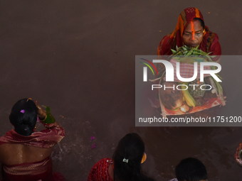 Hindu women devotees perform rituals in the river Ganga in front of the iconic Howrah Bridge during the Hindu festival Chhath in Kolkata, In...