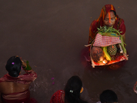 Hindu women devotees perform rituals in the river Ganga in front of the iconic Howrah Bridge during the Hindu festival Chhath in Kolkata, In...