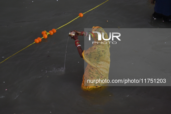 Hindu women devotees perform rituals in a water body of the river Ganga in front of the iconic Howrah Bridge during the Hindu festival Chhat...