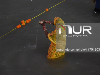 Hindu women devotees perform rituals in a water body of the river Ganga in front of the iconic Howrah Bridge during the Hindu festival Chhat...