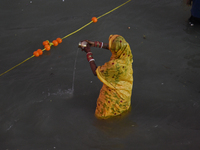 Hindu women devotees perform rituals in a water body of the river Ganga in front of the iconic Howrah Bridge during the Hindu festival Chhat...