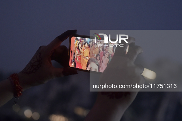 Hindu devotees take a selfie with a mobile phone during Chhath Puja near a sea beach in Mumbai, India, on November 7, 2024. The Chhath Festi...