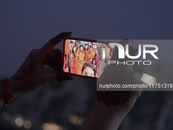 Hindu devotees take a selfie with a mobile phone during Chhath Puja near a sea beach in Mumbai, India, on November 7, 2024. The Chhath Festi...