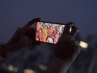 Hindu devotees take a selfie with a mobile phone during Chhath Puja near a sea beach in Mumbai, India, on November 7, 2024. The Chhath Festi...