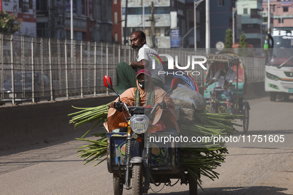 A rickshaw van driver transports passengers and vegetable goods to their destination in Dhaka, Bangladesh, on November 7, 2024. 