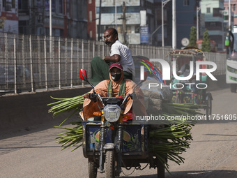 A rickshaw van driver transports passengers and vegetable goods to their destination in Dhaka, Bangladesh, on November 7, 2024. (