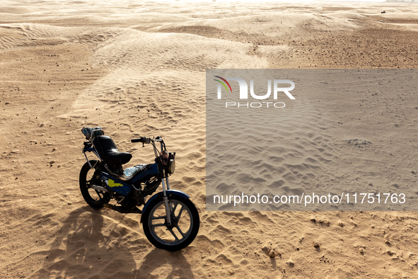 Motorbike is seen on dunes of Eastern Sahara desert on a sunny day on October 30, 2024 near Douz, Tunisia. 