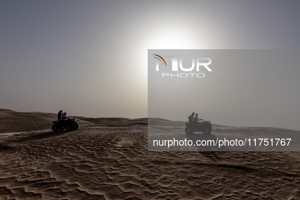 Tourists ride on quad bikes on dunes of Eastern Sahara desert on a sunny day on October 30, 2024 near Douz, Tunisia. 