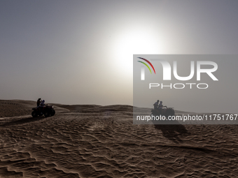 Tourists ride on quad bikes on dunes of Eastern Sahara desert on a sunny day on October 30, 2024 near Douz, Tunisia. (