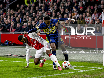 AFC Ajax Amsterdam defender Jorrel Hato and Maccabi Tel Aviv midfielder Issouf Sissokho play during the match between Ajax and Maccabi Tel A...