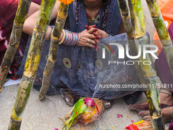 Hindu devotees perform rituals and offer prayers at sunset on the banks of the River Sabarmati during the Chhath Puja festival in Ahmedabad,...