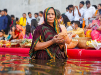 Hindu devotees perform rituals and offer prayers at sunset on the banks of the River Sabarmati during the Chhath Puja festival in Ahmedabad,...