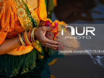 Hindu devotees perform rituals and offer prayers at sunset on the banks of the River Sabarmati during the Chhath Puja festival in Ahmedabad,...